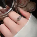Gros plan d'une élégante bague fer à cheval en argent avec zircons portée au doigt - Bague Boucle en Fer à Cheval / Or Café Léger