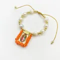 Detailed view of handmade religious bracelet with natural pearls and Guadalupe charm - Orange