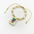 Detailed view of the Virgin of Guadalupe pendant on a handmade natural pearl bracelet. - White