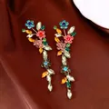 Detalle de pendientes vintage con flores de strass de colores sobre tela marrón - Estilo 2 / Dorado-Multicolor
