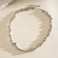 Detailaufnahme der unregelmäßigen silbernen geometrischen Perlen und der gebogenen Metallkette - Silber
