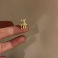 Detailed macro shot of a sparkling crystal-encrusted teddy bear gold ear cuff on a finger - Single Piece / Gold