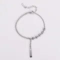 Detail of a silver chain bracelet with a sleek bar pendant and pig-nose links. - Steel