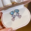 Gedetailleerde macro-opname van zilveren oorknopjes met blauwe paarse roze kristallen - Stijl 35 (HE32568)