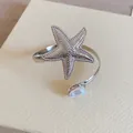 Detaillierte Makroansicht eines silbernen Seestern-Armreifs mit einer eleganten Perle - Seesternform (Mit Perle) / Silber
