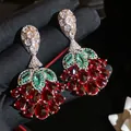 Makrodetail exquisiter Ohrringe mit roten und grünen Edelsteinen auf schwarzem Handschuh. - Stil 4 (HE32568) / Silber Grün Rot