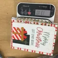 Libro per carte regalo di Natale con copertina rossa e bianca su una bilancia - Carte regalo