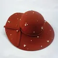 Close-up of orange wool felt hat featuring pearl bead accents and a side knot detail - Tan