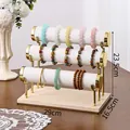Three-tier white and gold bracelet display stand with a natural wooden base - Triple Layer / White Leather