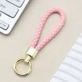 Portachiavi intrecciato in pelle PU rosa con anello a molla dorato e parti metalliche lucide - Fibbia Intrecciata con Anello a Molla / Rosa Chiaro