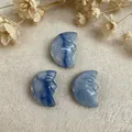 Macro shot of three hand-carved blue stone moon face pendants on a linen background - Blue Aventurine