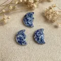 Hand-carved blue sodalite moon face pendants with natural white vein textures - Blue Spot Stone