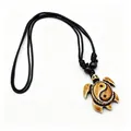 Detail view of a resin sea turtle pendant featuring a Yin Yang symbol on black cord. - Red Brown