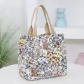 Canvas handbag with cartoon cat prints and thick woven handles on a white table - White Cat