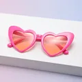 Hot pink heart shaped sunglasses with orange lenses and glitter finish on a display - C4