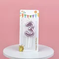 Macro view of metallic pink balloon-style number 3 birthday candle in retail packaging - Rose Gold Number 3 Candle