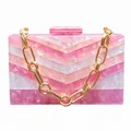 Detailansicht der Acryl-Clutch mit rosa Chevron-Muster und goldener Kettenriemen - Mit Handkette