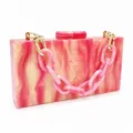 Detail of pink marble acrylic evening clutch with thick chain strap and gold hardware - With Hand Chain