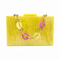 Detalle de bolso de mano de acrílico amarillo mármol con cadena de oro y aros lila - Amarillo (Con Cadena de Mano Decorativa)