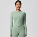 Detail of mint green yoga set featuring thumb holes and slim-fit V-hem zip jacket - 7106 Zipper Jacket - Basil Green / S