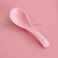 Pink matte ceramic spoon with hanging hole shown on a matching pink background - Peach