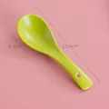 Matte bright green ceramic soup spoon with a hanging hole, size 13.5x4.3cm on pink background - Grass Green