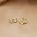 Elegant gold-tone mask stud earrings with white rhinestones on champagne satin fabric - Gold E2-1
