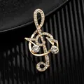 Luxury gold treble clef music brooch with sparkling crystals on a textured black stand - Double Rhinestone G-Clef Gold (XD9425-4)
