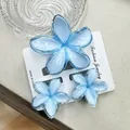 Set of three translucent light blue plumeria flower hair clips on display card - Blue Set With Transparent Snap Closure (including Card)