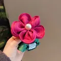 Coletero floral artesanal rojo rosa con perla blanca y detalle de hoja verde - Coletero de flor con perlas magenta