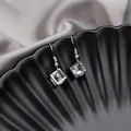 Close-up of silver tassel earrings with hollow cube design and clear square crystals - Silver Hollow Cube Zirconia