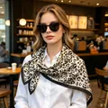 Elegant 70cm leopard print silk scarf with black border worn by model in a cafe setting - 70cmx70cm / Black & White Leopard (New Black/White)