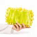 Detail of marbled acrylic evening clutch bag with yellow pearl bead trim - Yellow