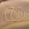Minimalist large golden hoop earrings with a polished finish on brown silk fabric - 5cm Diameter/Gold