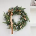 Kerstkrans van dennennaalden met champagne gouden bessen en lint op witte muur - Stijl 25-27