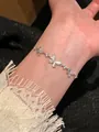 Elegant silver butterfly charm bracelet with sparkling zircons worn on wrist - Heart and Butterfly Intertwined Bracelet