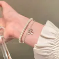 Double-layered pearl bracelet featuring a silver bow pendant for women - Korean Style Bowknot Pearl Layered Bracelet
