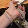 Delicate gold and silver bracelets with micro-p鑲 stones on warm wood background - Sparkling Money Bag Wrap Bracelet Gold