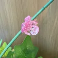 Pink octopus hair claw clip made of acetate on green plant stem with a wood background - Pink Small Octopus