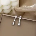 Polished silver double teardrop stud earrings on a dark brown display stand - Silver Minimalist Double Waterdrop Studs (E3499-2) / Silver