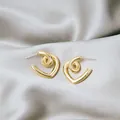 Elegant gold heart earrings with twisted metal design on a luxury grey satin background - Spiral Twisted Heart Geometric Earrings (E4733) / Gold