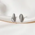 Polished silver organic pebble stud earrings resting on white elegant silk fabric - Shiny Silver Irregular Streamlined Mirror Finish Stud Earrings (E4791) / Bright Silver