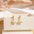 Elegant gold-plated windmill earrings featuring a central white pearl on silk fabric - Gold Windmill Shape Pearl Stud Earrings (E2714-1) / Gold