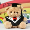 Detailansicht eines braunen Absolventen-Teddybären mit Talar und schwarzem Doktorhut. - Weiße Geschenkttüte / 25cm / Abschlussbär - Braunbär Schwarze Robe Weißer Kragen
