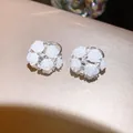 Detailopname van elegante zilveren oorbellen met witte gesneden rozen en kristallen - Rozencluster Oorknopjes (52#)
