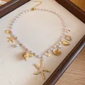Detailansicht der Perlenhalskette mit goldenem Seestern und natürlichen Muschelanhängern - Urlaubskette mit Seestern- und Muschel-Anhänger und Perlen / Gold-Weiß
