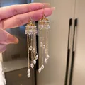 Dettaglio di orecchini lunghi a nappa dorata con cristalli trasparenti - 41# Ear Hook - Alloy Crystal Style / Oro