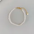 Gros plan d'un bracelet en perles d'eau douce baroques avec fermoir doré et tag - Bracelet Style B bp5-6 (17+3cm)