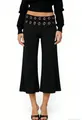 Detailed view of women's black wide-leg trousers featuring decorative silver metal eyelets - S