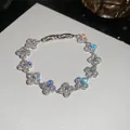 Detailed close-up of a silver four-leaf clover bracelet with sparkling clear stones. - Clover Style (Pave) / Silver with White Stone